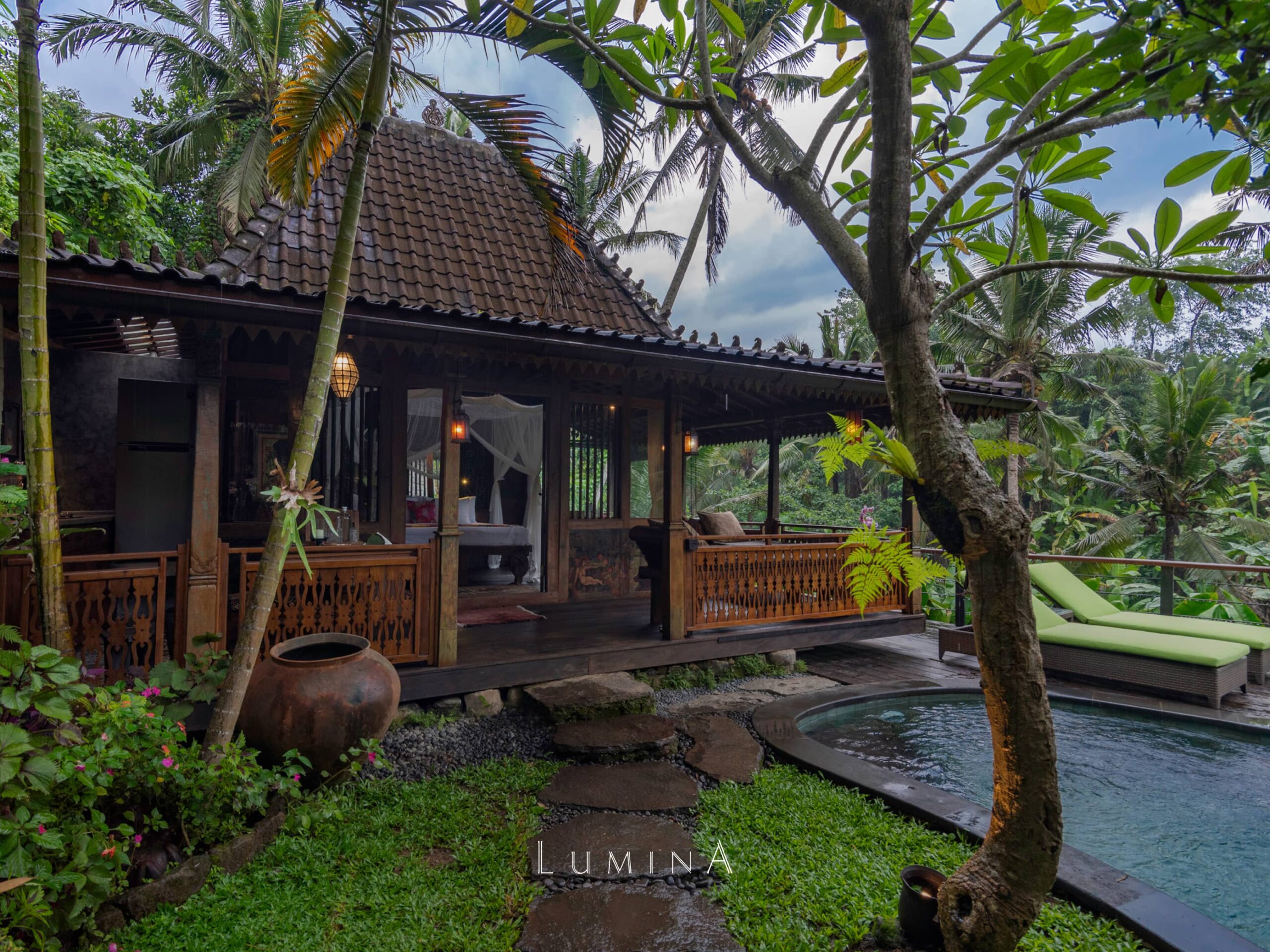 Traditional wooden villa with private pool surrounded by tropical garden at Lumina Bali